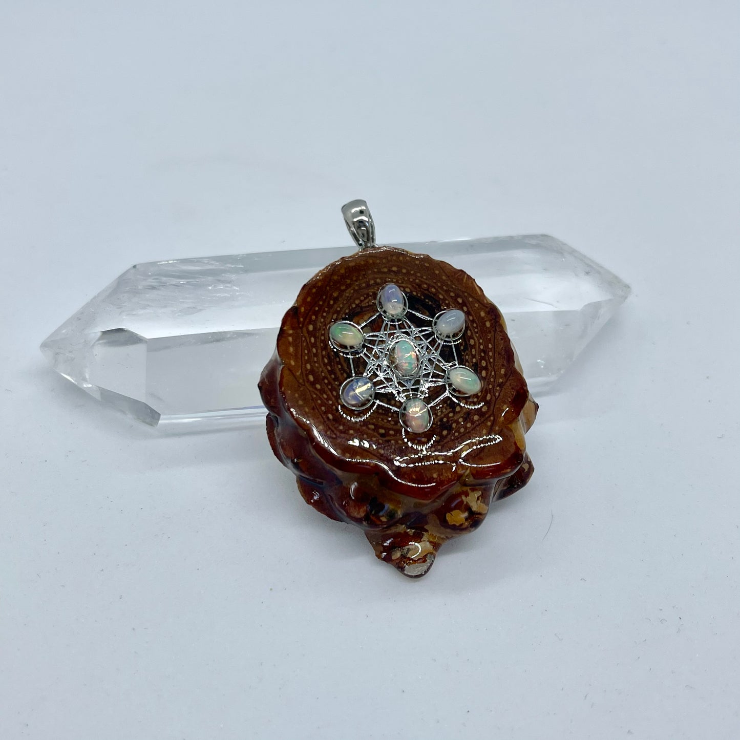 opal pinecone pendant displayed on quartz crystal