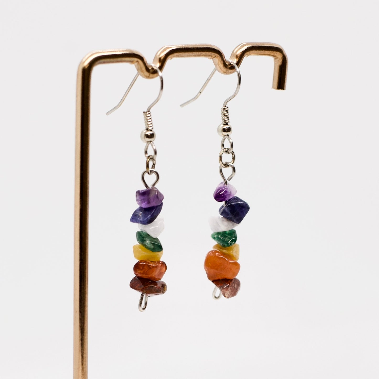 closeup of chakra gemstone dangle earrings on display stand