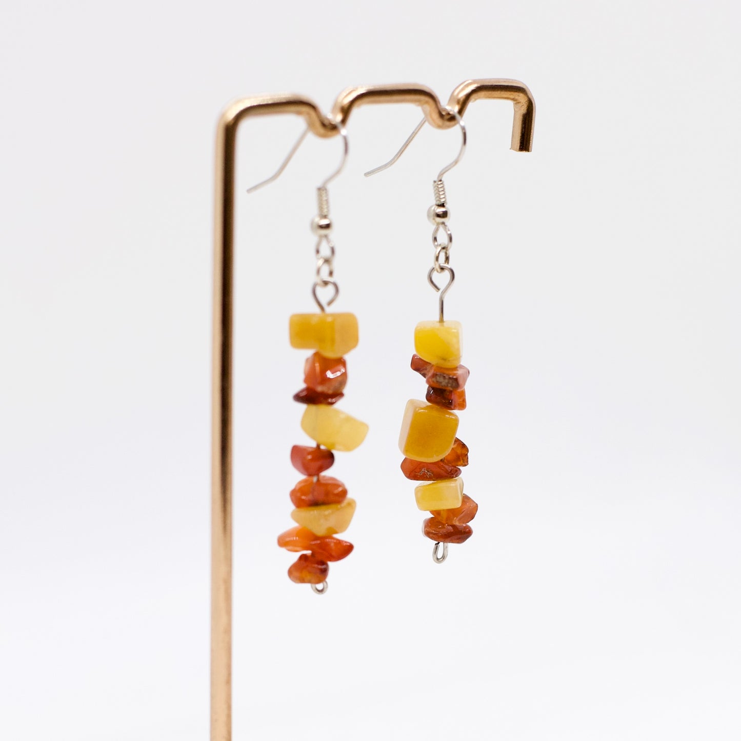 close up of Carnelian and Yellow Aventurine Gemstone Earrings on display stand with white background