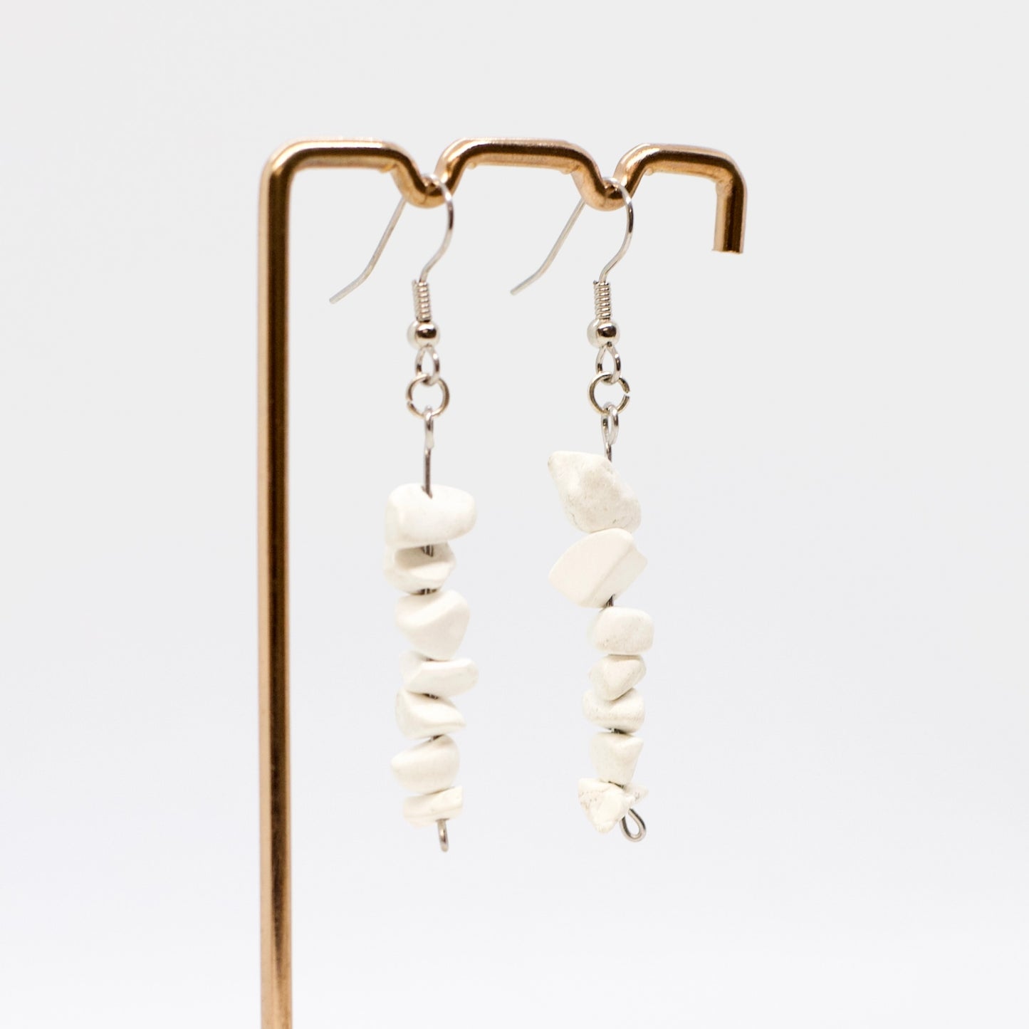 howlite gemstone chip earrings with silver earring hooks on display stand 