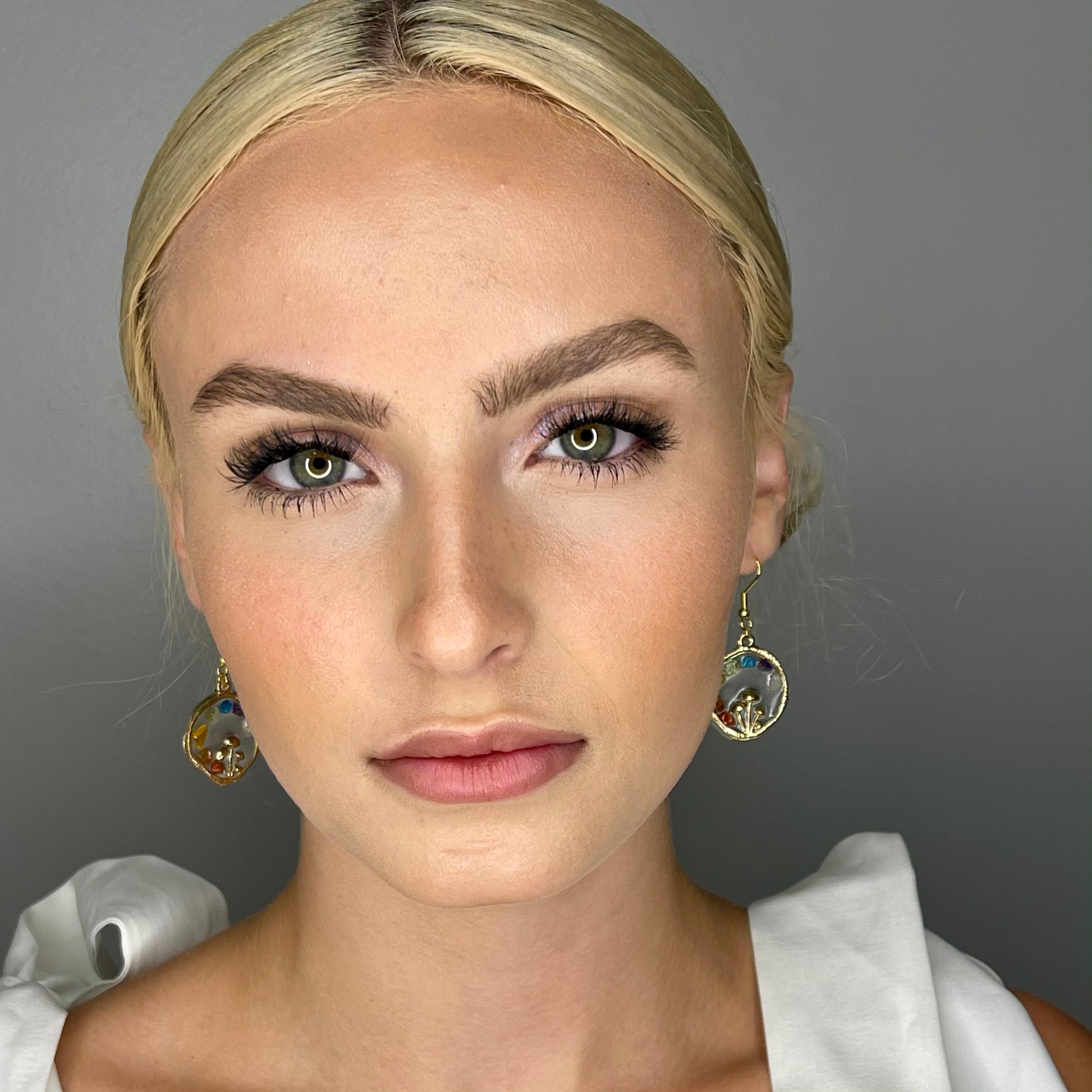 Model wearing chakra mushroom earrings 