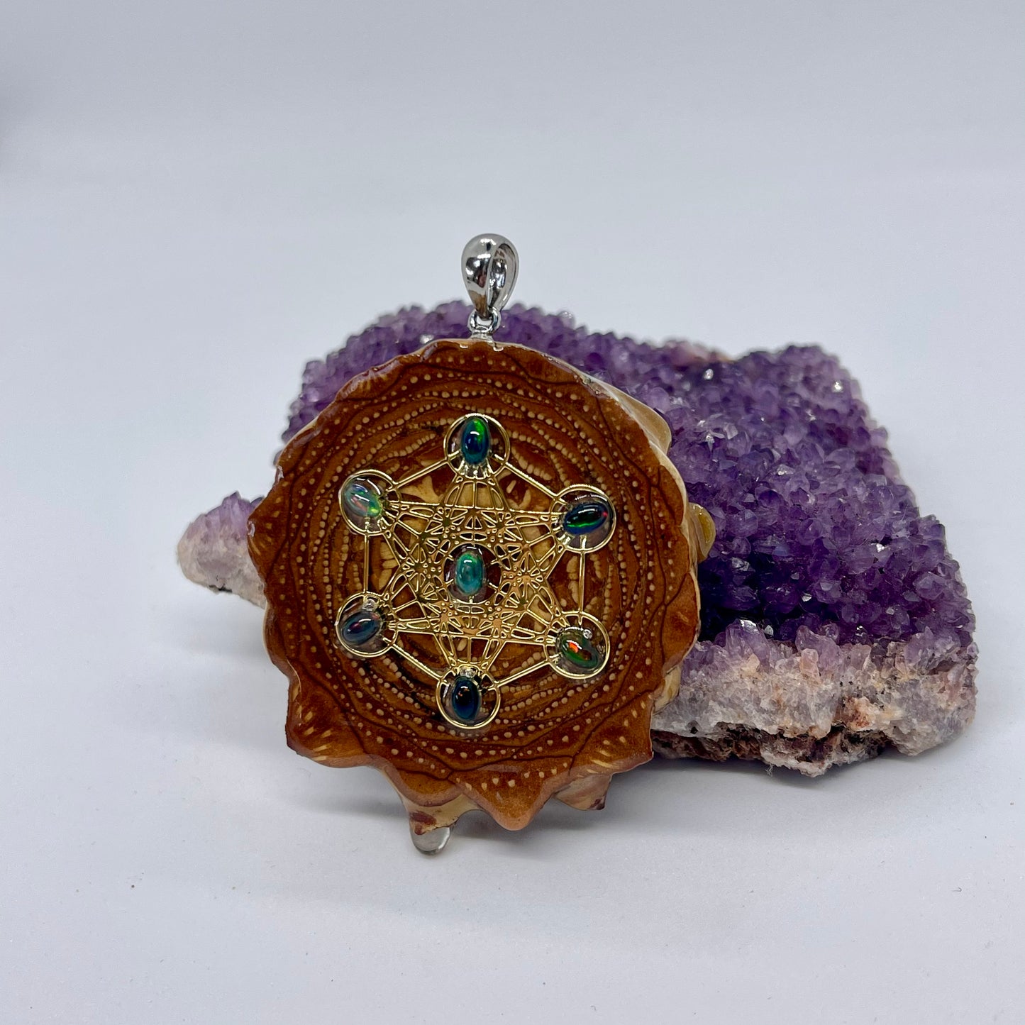 Left side view of pinecone pendant with black Fire Opals and Metatron's Cube symbol displayed on crystal