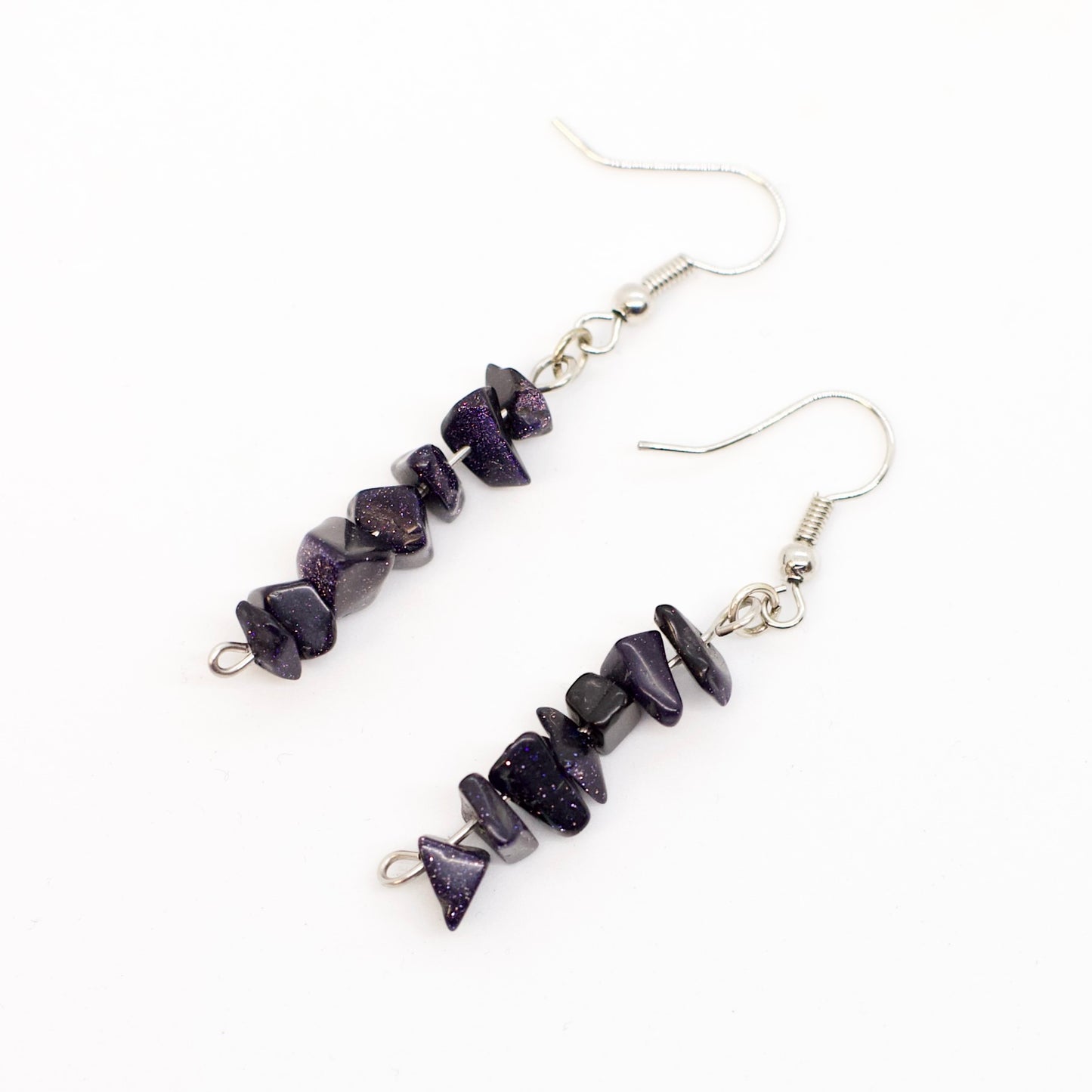 close up of Blue Goldstone gemstone chip earrings on white background