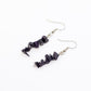 close up of Blue Goldstone dangle gemstone chip earrings on white background
