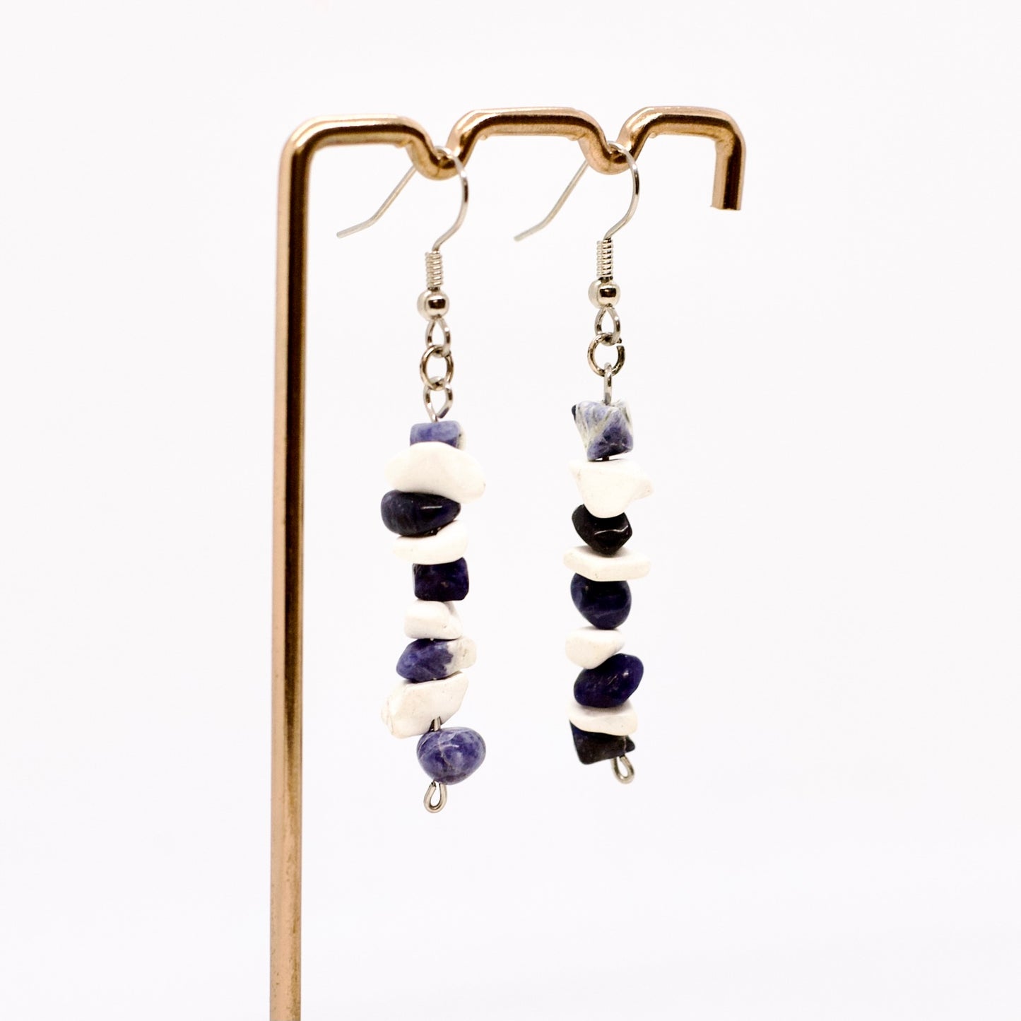 sodalite and howlite gemstone chip dangle earrings on display stand with white background 