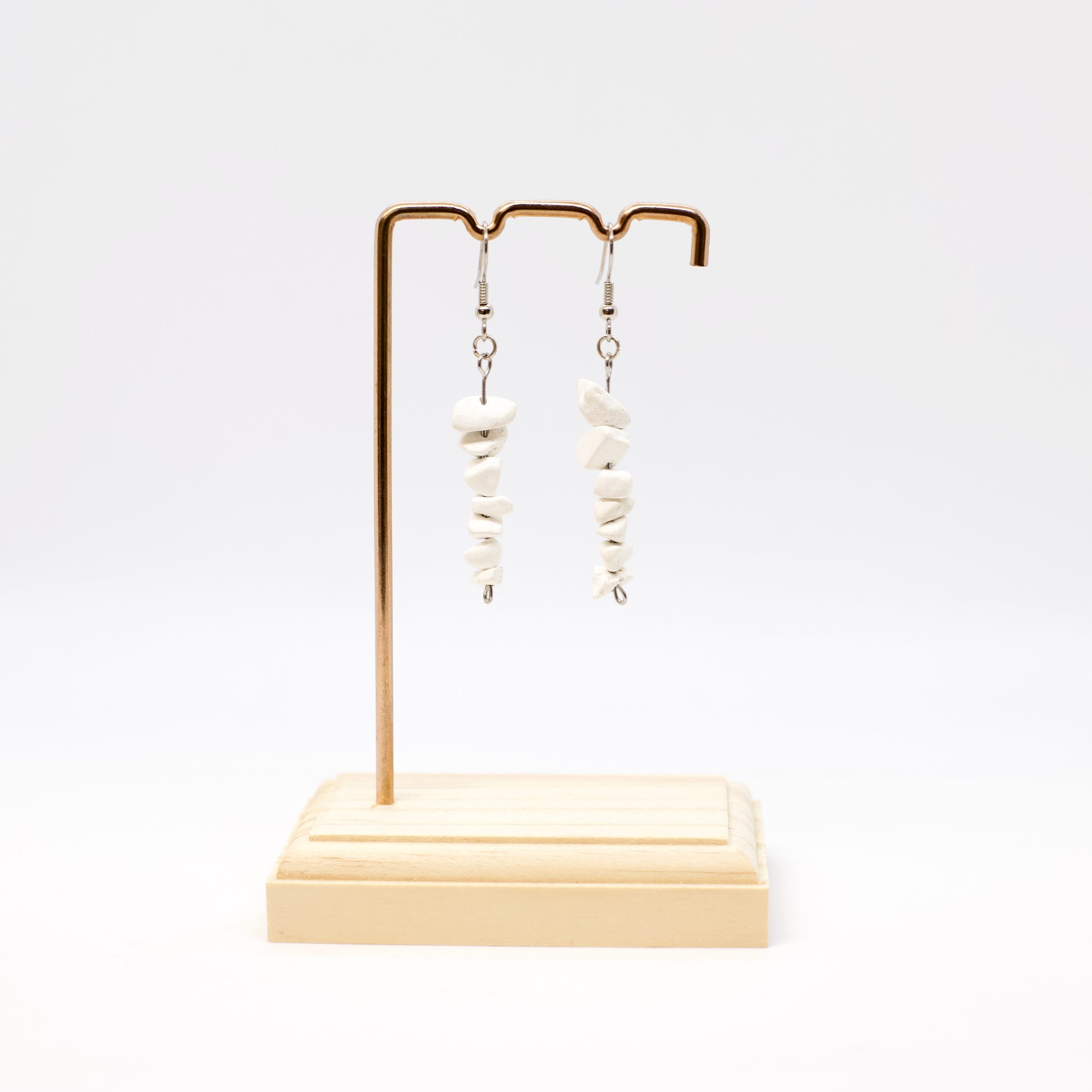 Howlite gemstone dangle earrings on display stand 