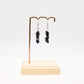 Blue Goldstone gemstone chip earrings on display stand with white background