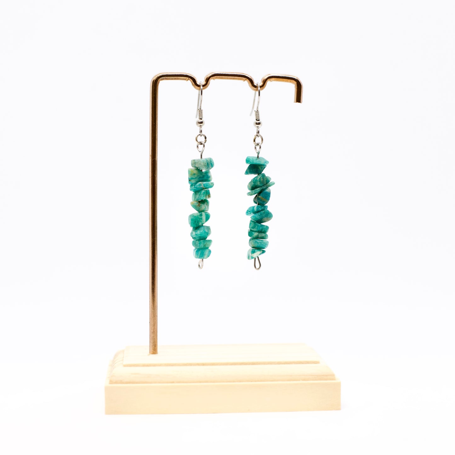 Amazonite gemstone dangle earrings on gold earring stand on white background