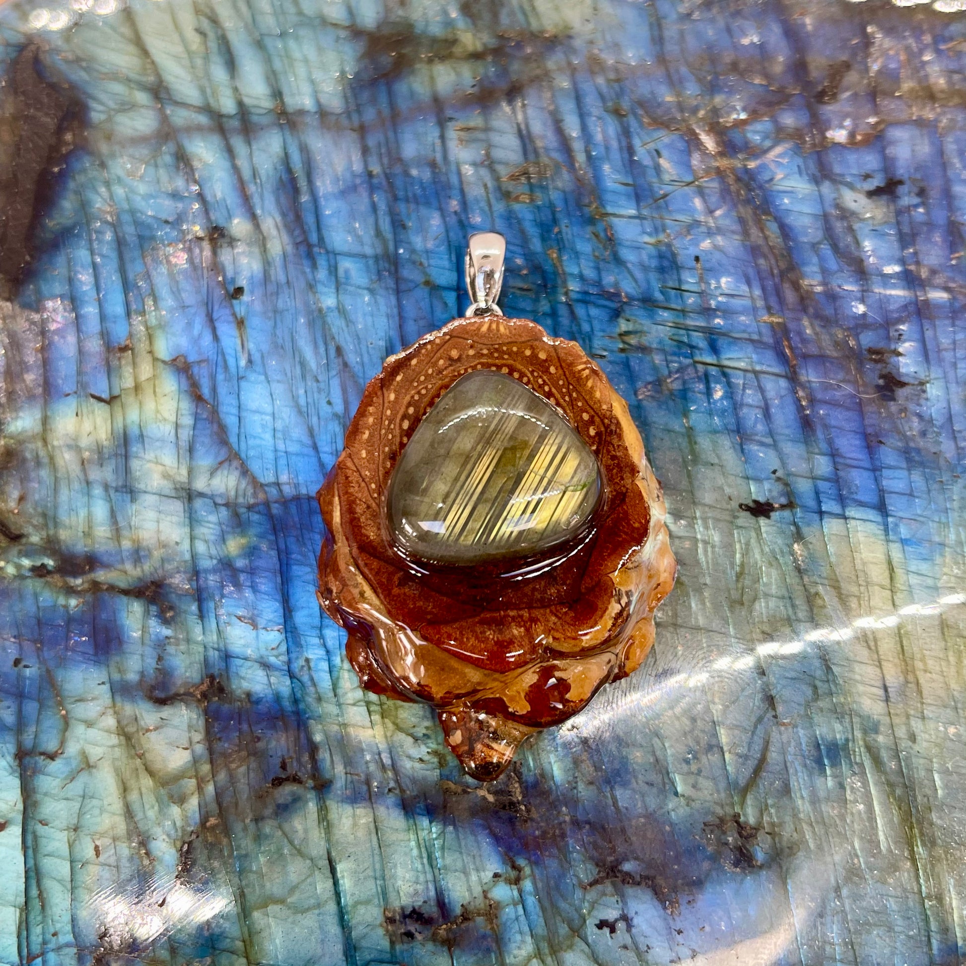 pinecone pendant with labradorite gemstone shaped as teardrop on colorful background
