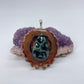 Pinecone pendant with Kambaba jasper stone displayed on crystal