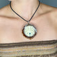 close-up of model wearing pinecone pendant with opal and octopus  