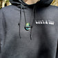 close up of model wearing black hoodie with life's a trip printed on front