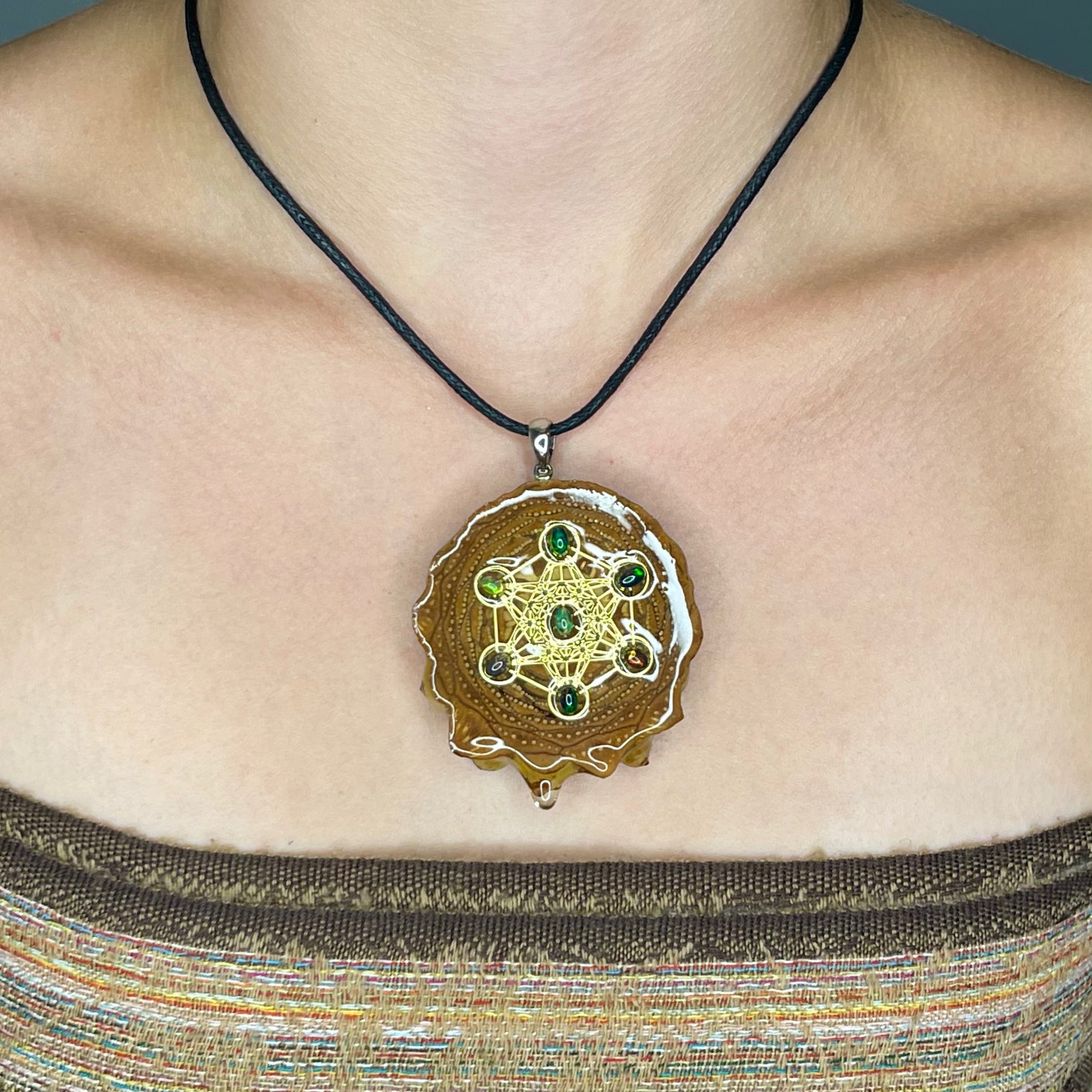close up of model wearing pinecone pendant with fire opals 
