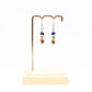Chakra gemstone chip earrings on display stand with white background 