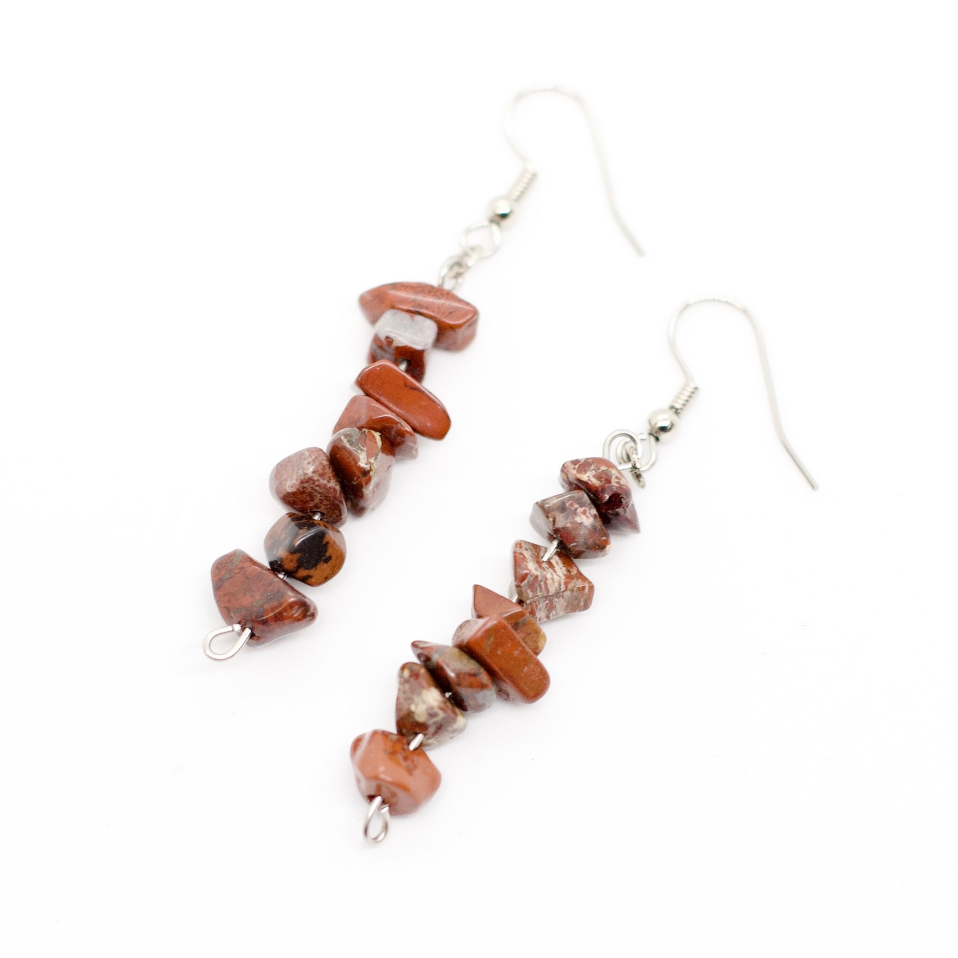 closeup of red jasper gemstone chip dangle earrings on white background 