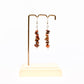 red jasper gemstone dangle earrings on display stand 