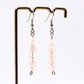 close up of rose quartz gemstone chip dangle earrings on display stand 