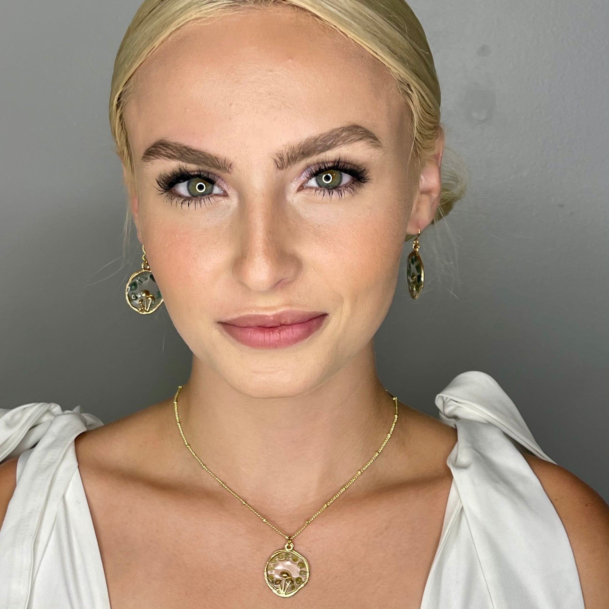 model wearing gold mushroom necklace with peridot gemstone chips 