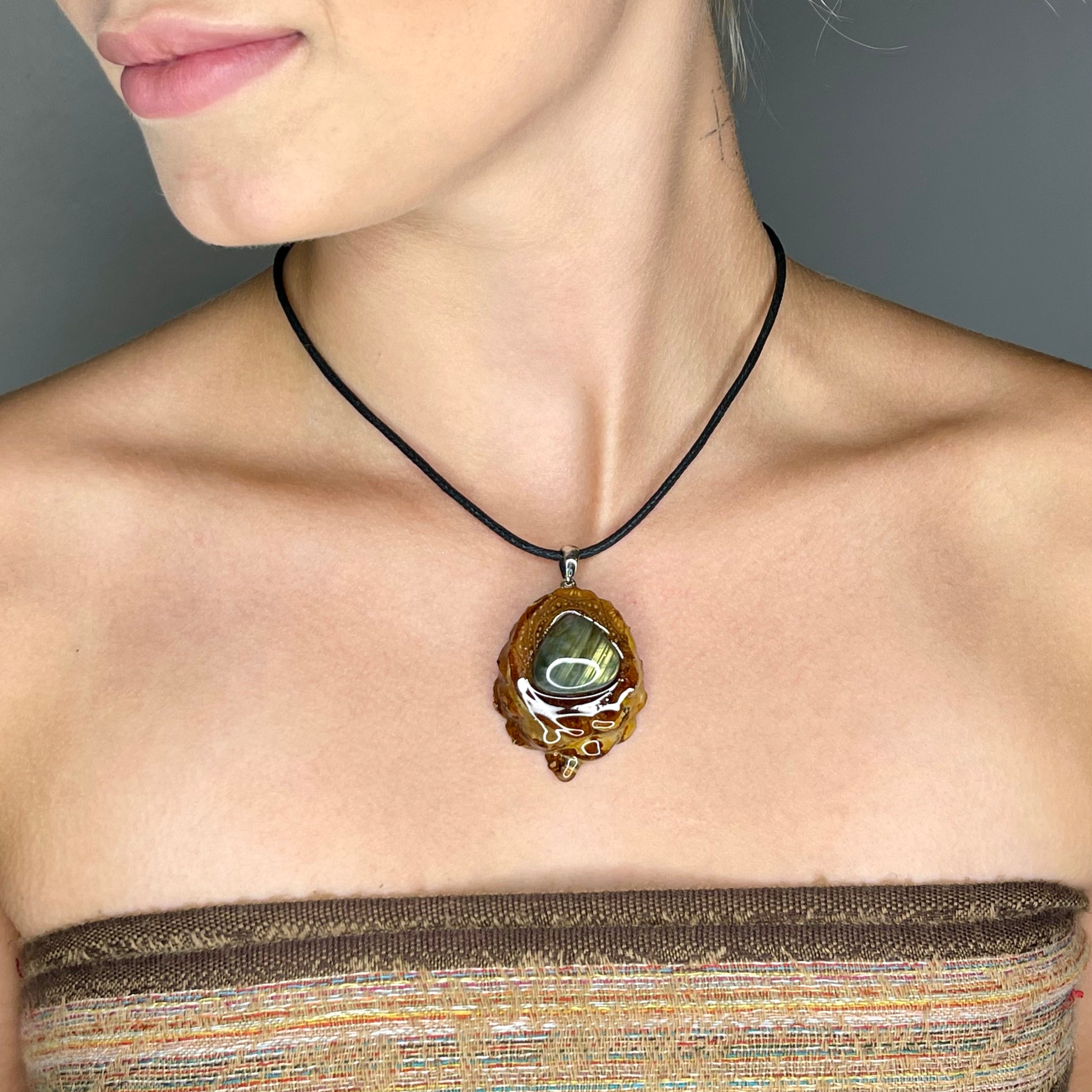 close up of model wearing pinecone pendant with teardrop shaped labradorite gemstone 