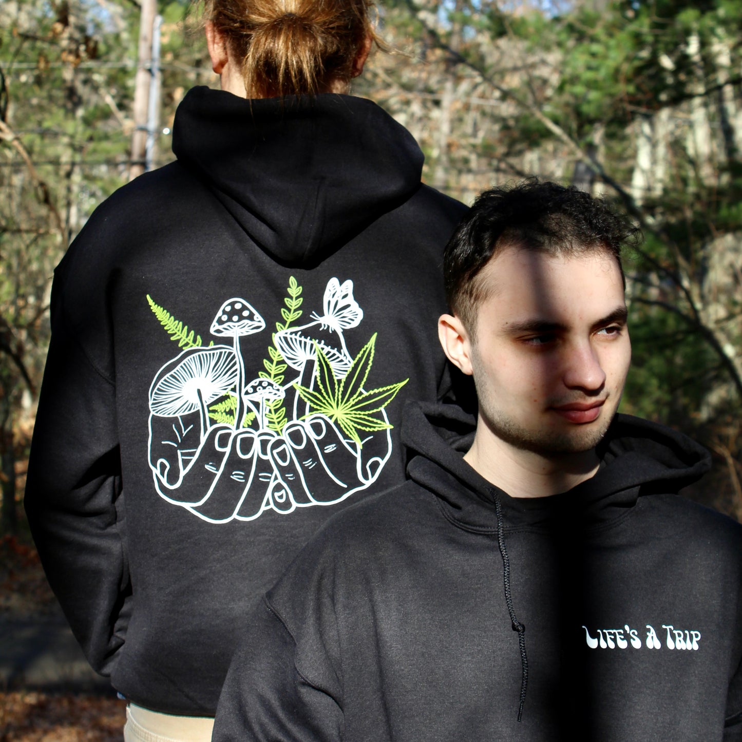 two models wearing black hoodie with custom green and white mushroom design 