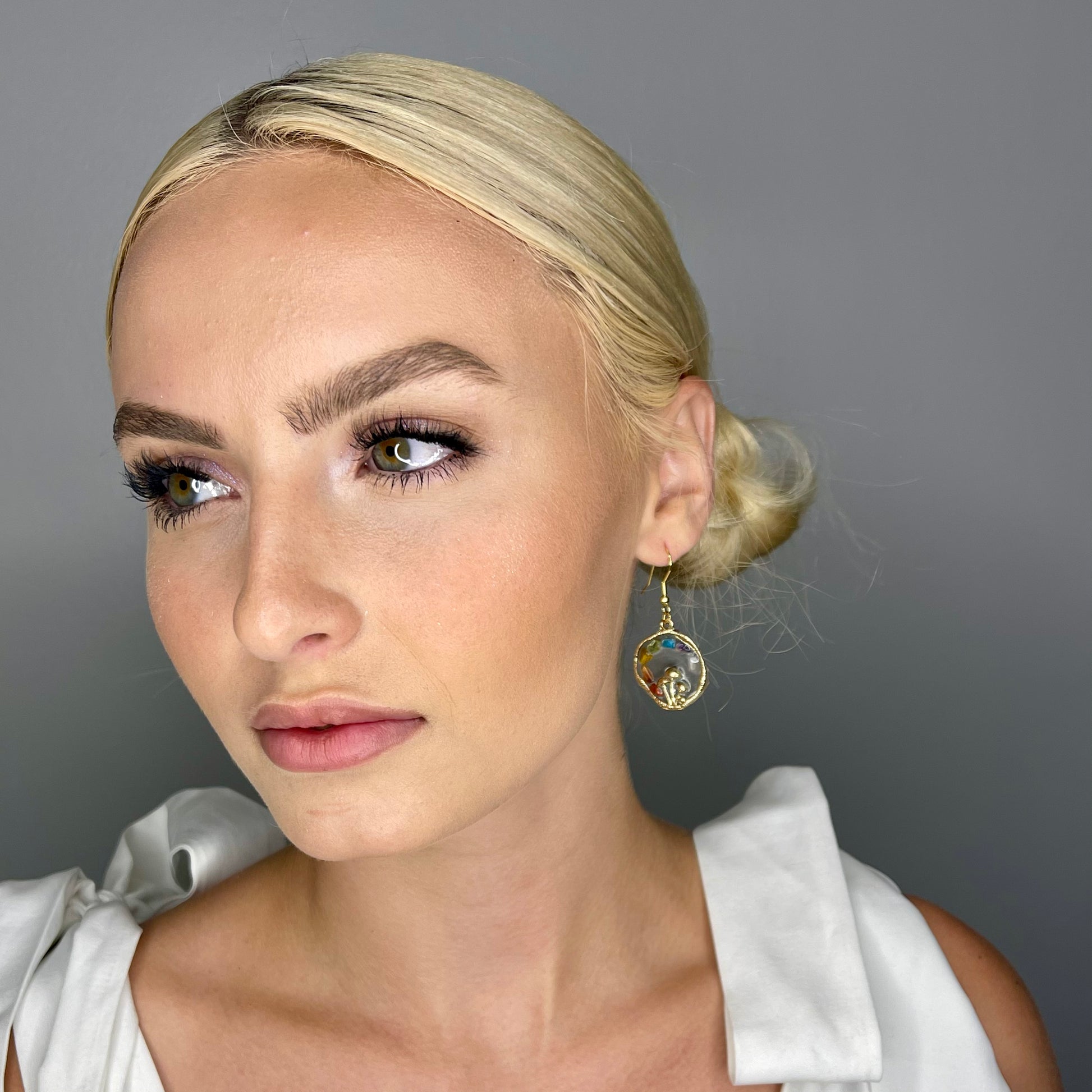 model looking to the side modeling chakra mushroom earrings 
