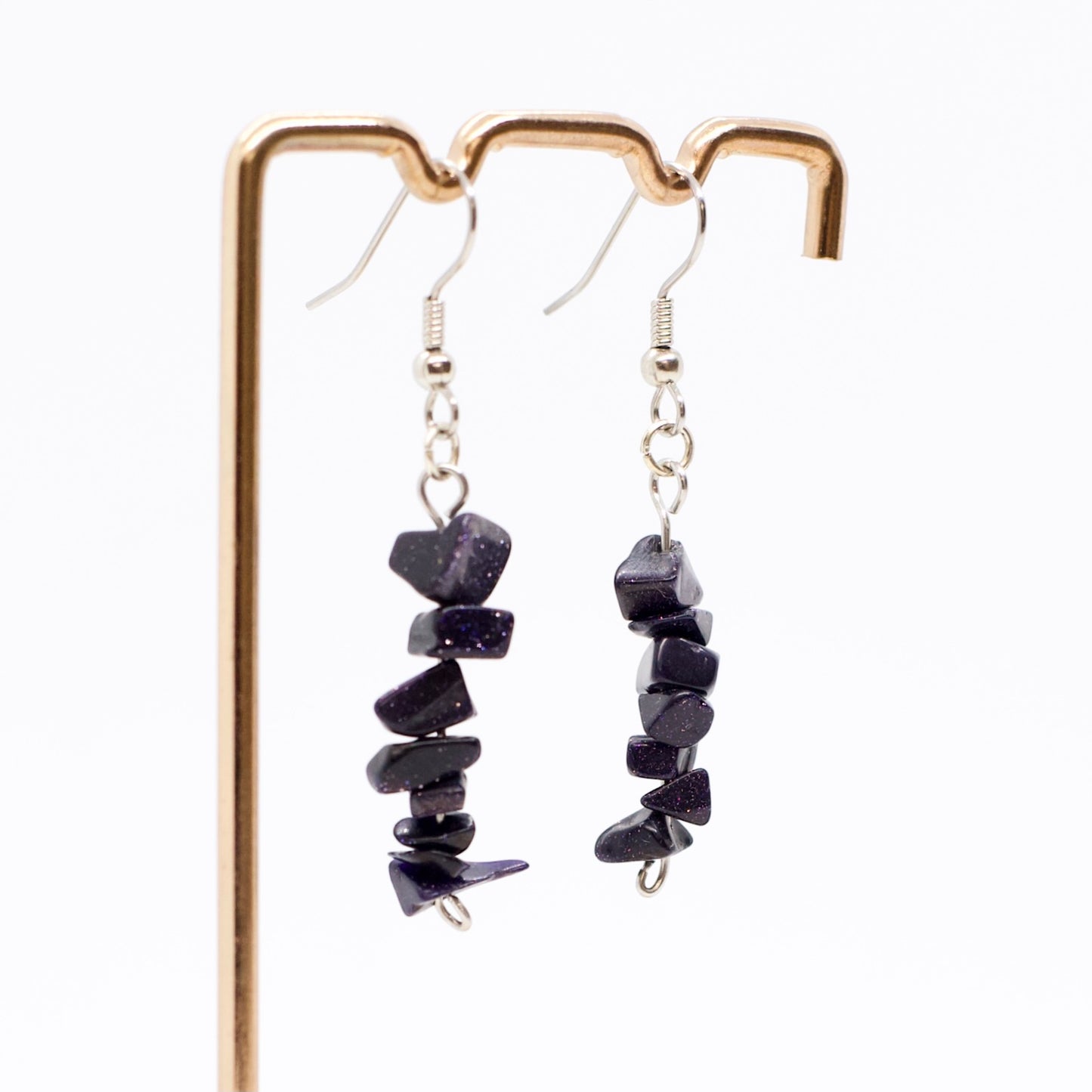 close up of Blue Goldstone earring on display stand with white background 