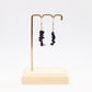 Blue Goldstone gemstone earrings on display stand with white background